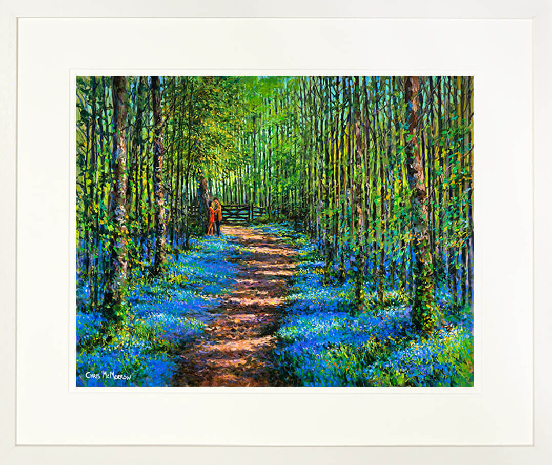 A framed print of a painting of two lovers pausing on a path through a bluebell wood