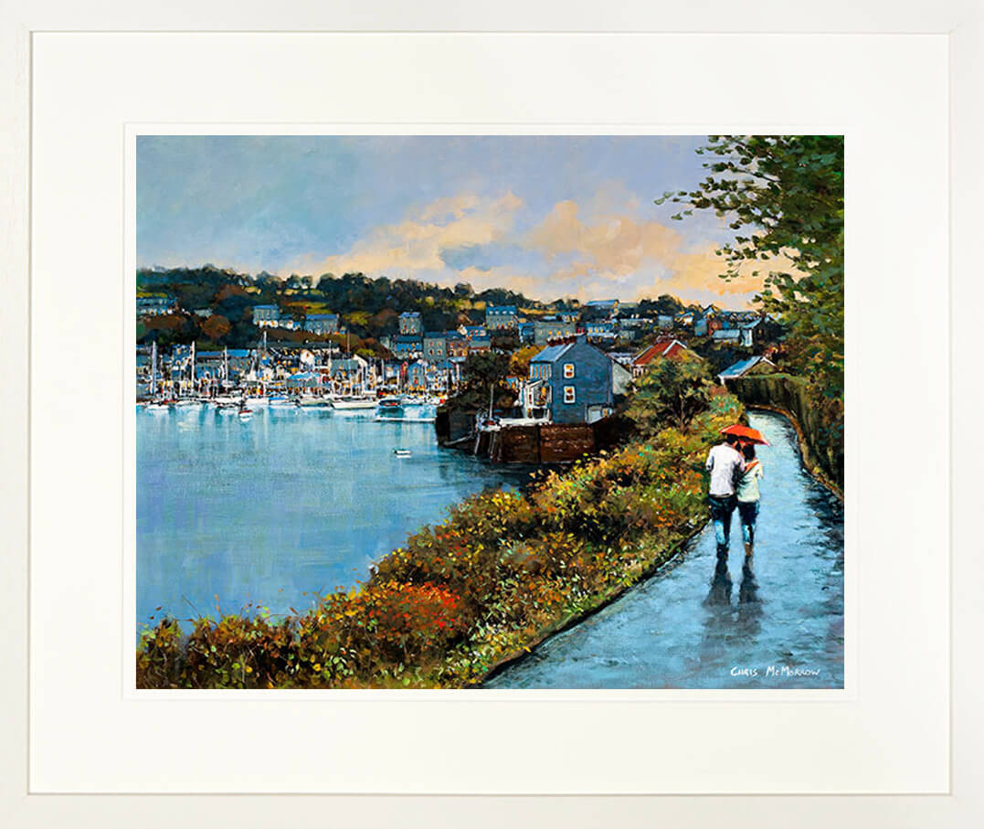 A framed print of two people walking along the Scilly Walkway in Kinsale, County Cork