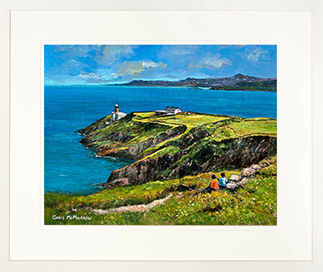 A framed print of a painting of a couple looking out over the sea and the Baily Lighthouse, Co Dublin