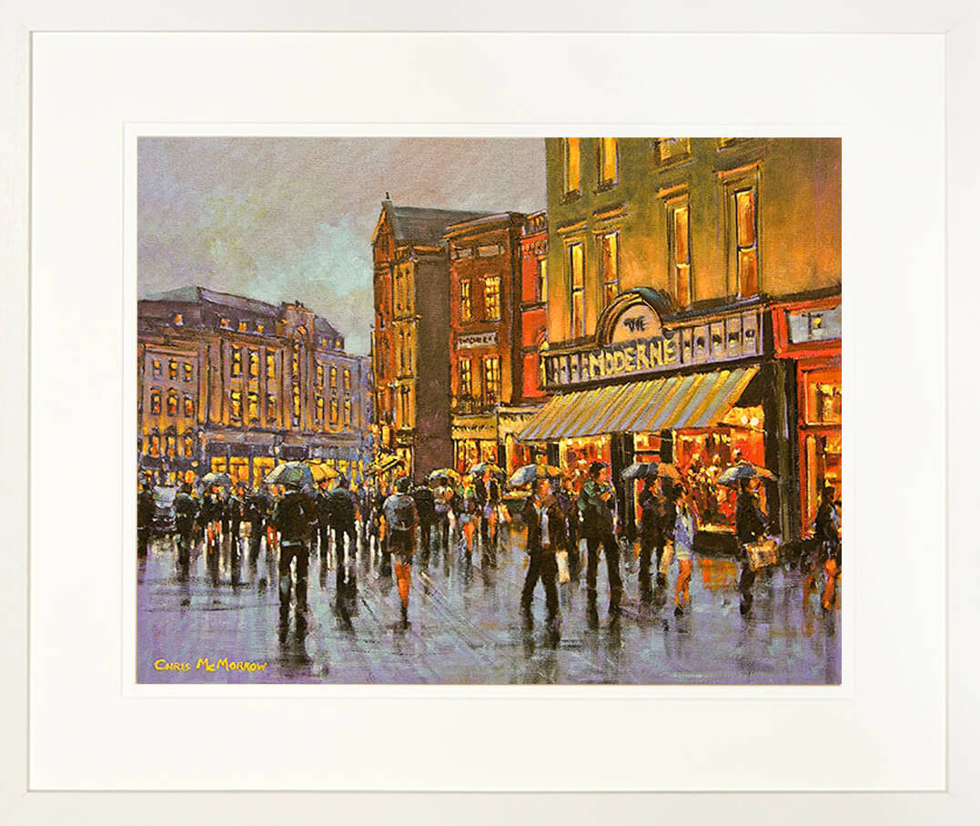 A framed print of a painting of people passing the front of the Moderne Bridal shop in Cork City centre