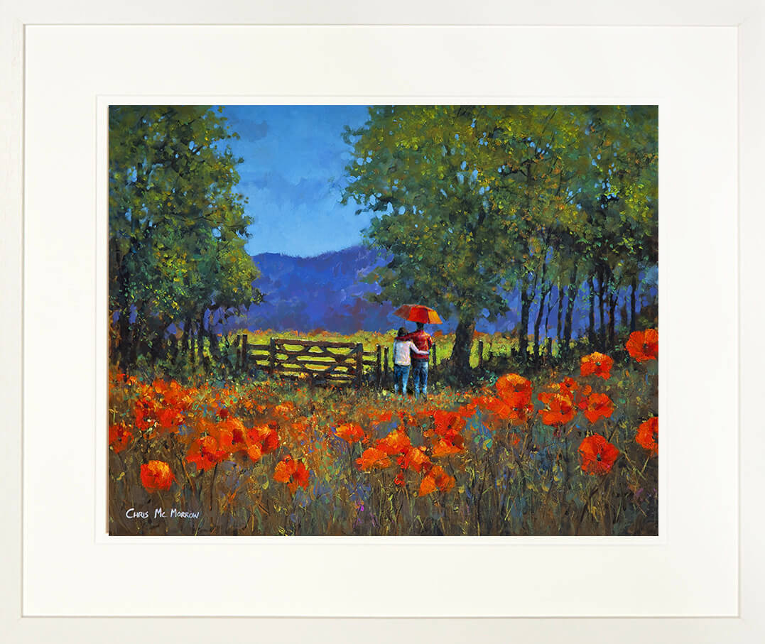 Framed print of a couple under an umbrella in a field of red poppies with trees and mountains in the background.