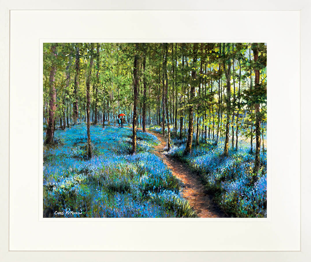 A framed print of a painting of two lovers taking a stroll along a path among the bluebells in a wood