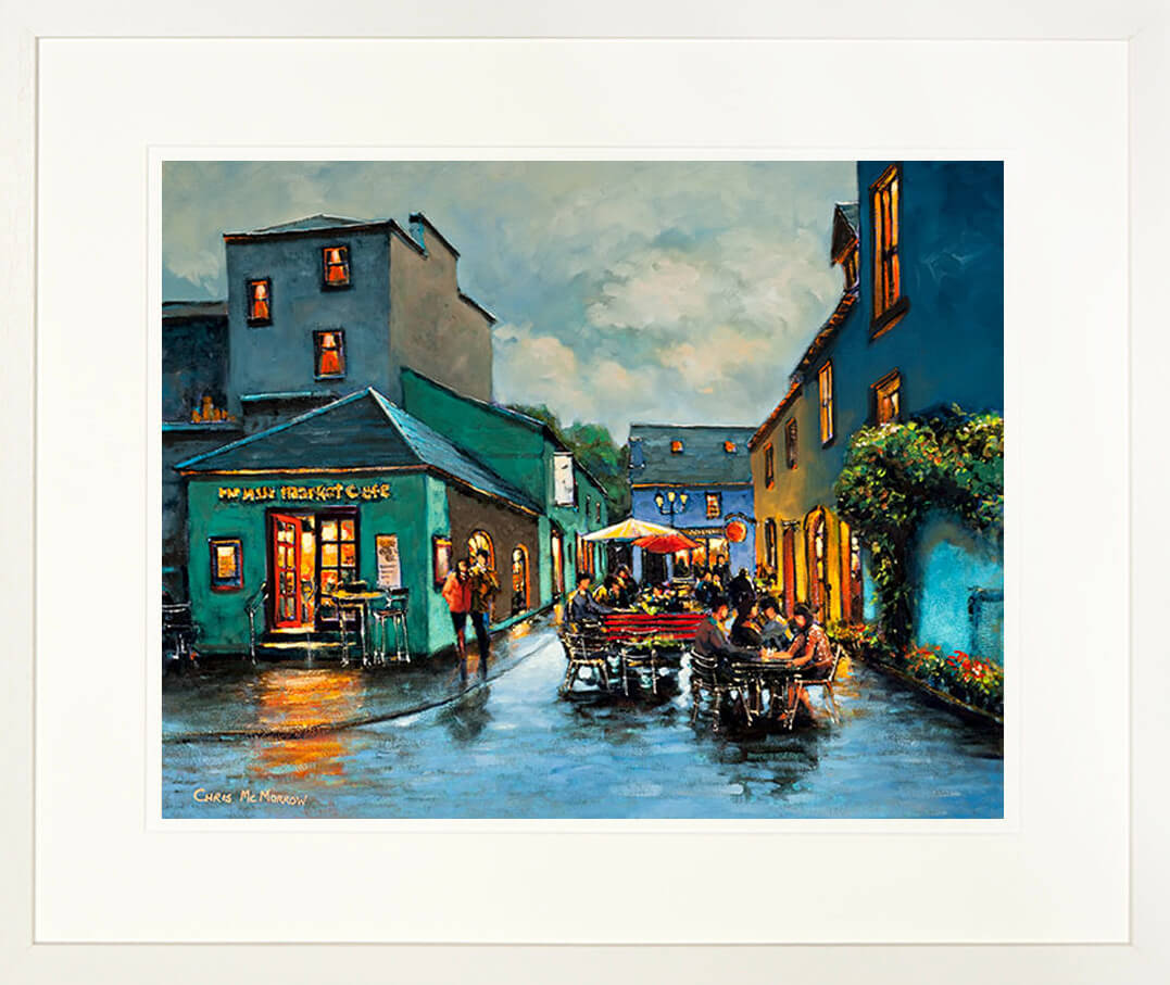 A framed print of a painting of people outside a café at the Milk Market in Kinsale town , County Cork