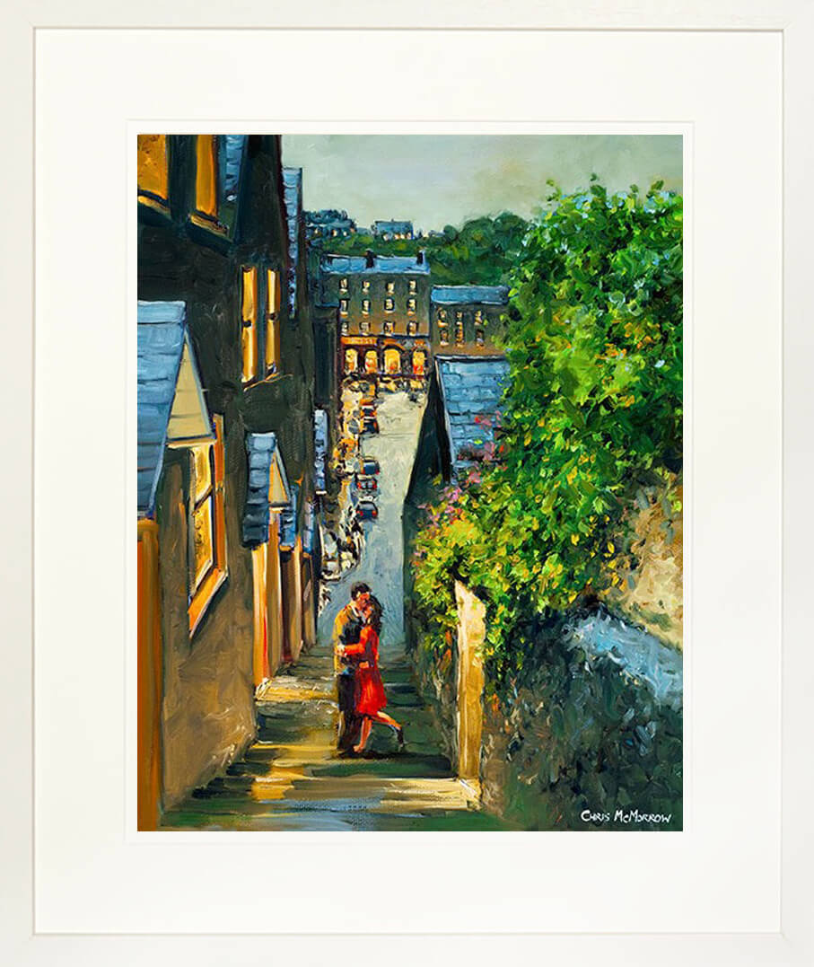 A framed print of a romantic painting of lovers kissing on steps in Kinsale, County Cork