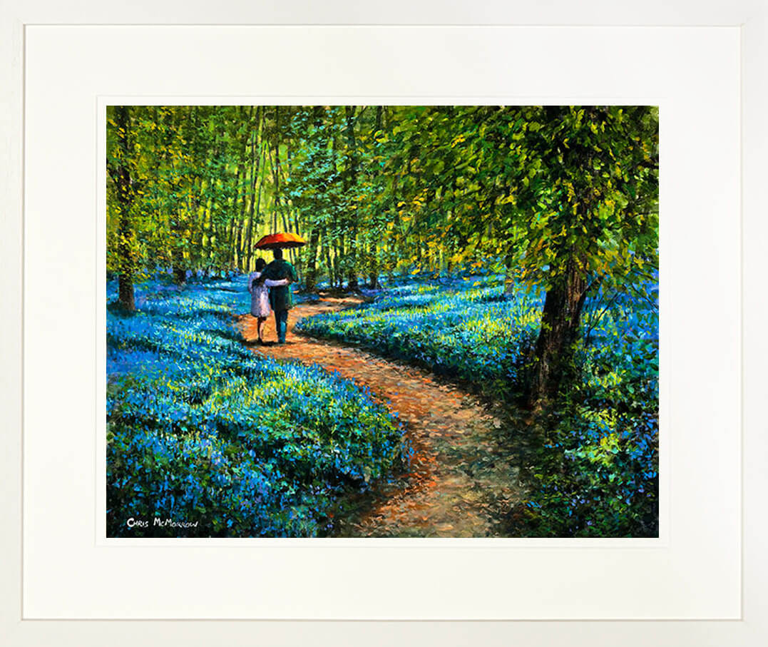 A framed print of a painting of two lovers with an umbrella walking among the bluebells