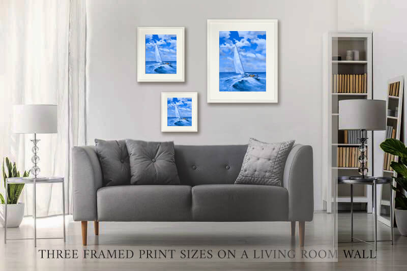 sofa in a living room with three framed sailboat prints on the wall.