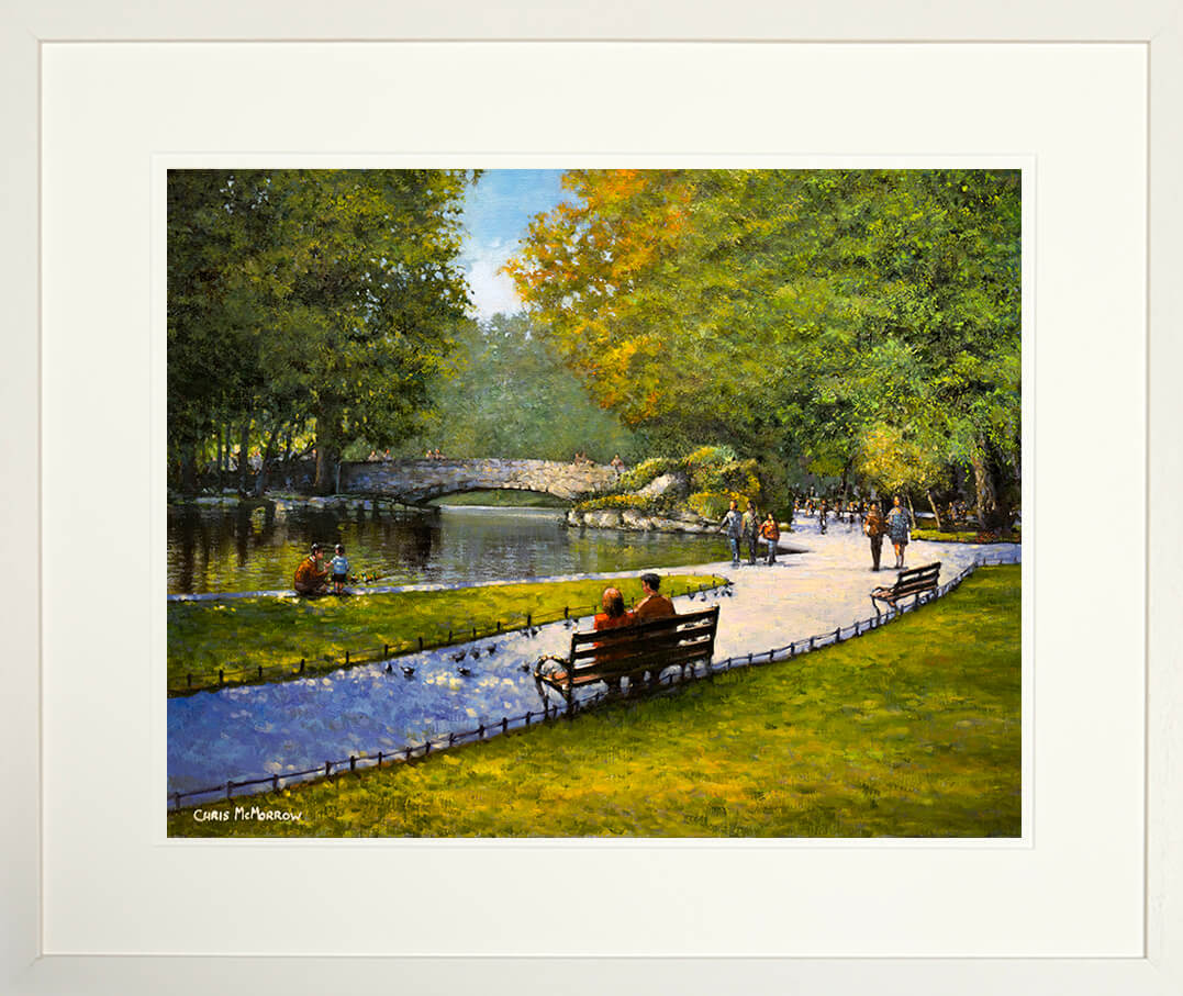 Framed print of a Park scene with people sitting on a bench by a pond, surrounded by trees with autumn foliage.