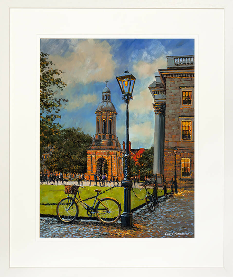 A framed print of a painting titled Bicycle, Trinity College by artist Chris McMorrow