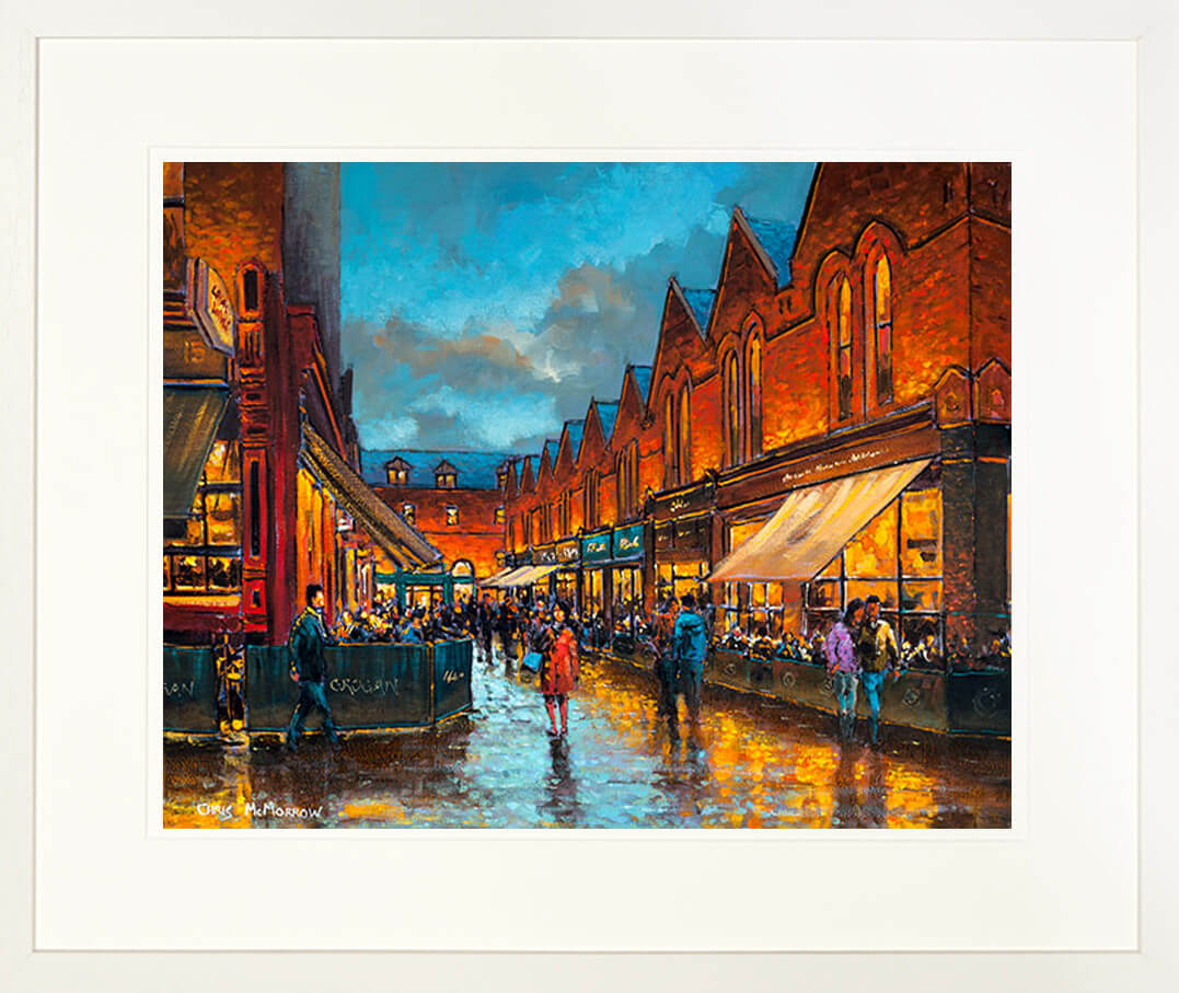 A print in a cream frame of a painting called Castlemarket Reflections showing a small street and cafes in Dublin city centre