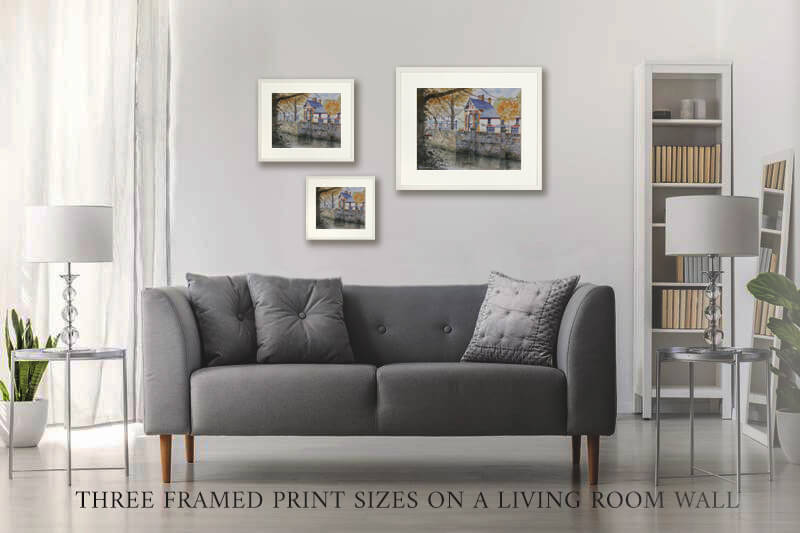 Gray sofa in a living room with three framed prints of Kennys on the wall.