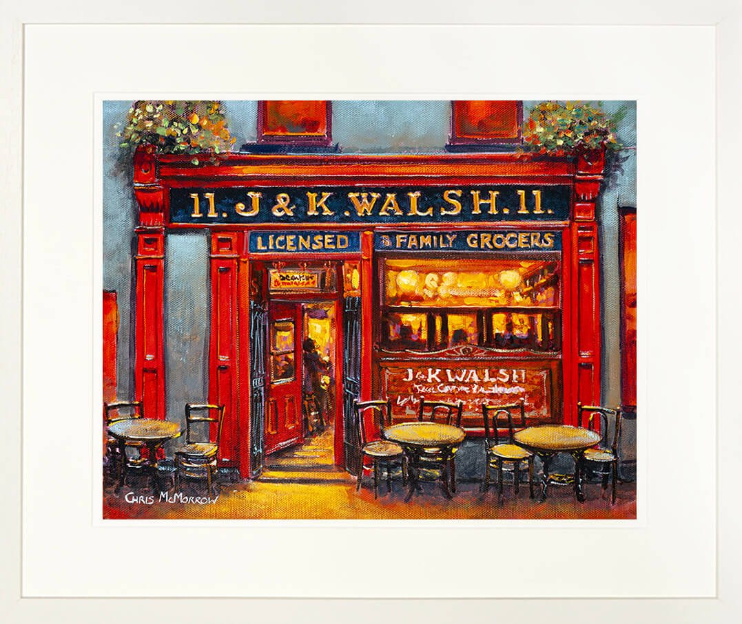 A framed print of the front facade and entrance to &#39;JK&#39;s &#39;, Walshs bar on Georges Street, Waterford city centre, lit up in the evening time.