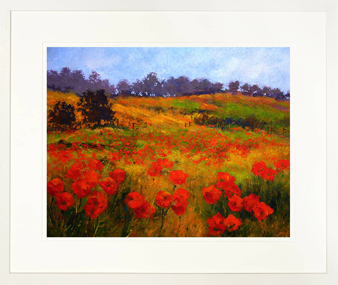 A framed print of a painting of a field of poppies on a rolling hillside landscape