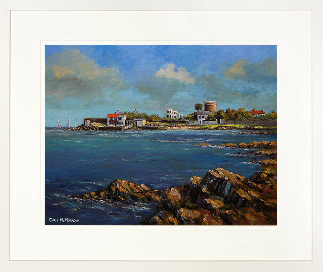 A framed print of a seascape painting showing the rocks at the waters edge in Sandycove, County Dublin