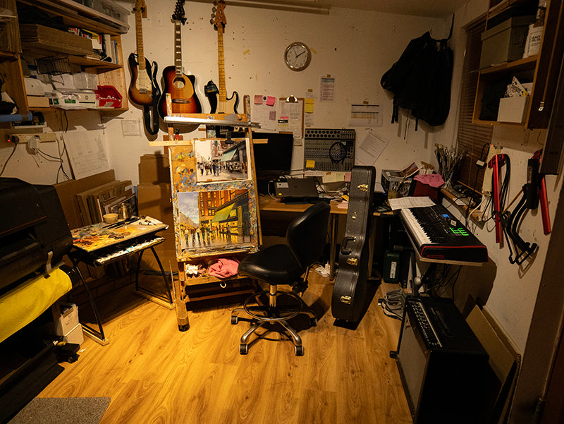 Photo of an art studio and the artist working at his easel