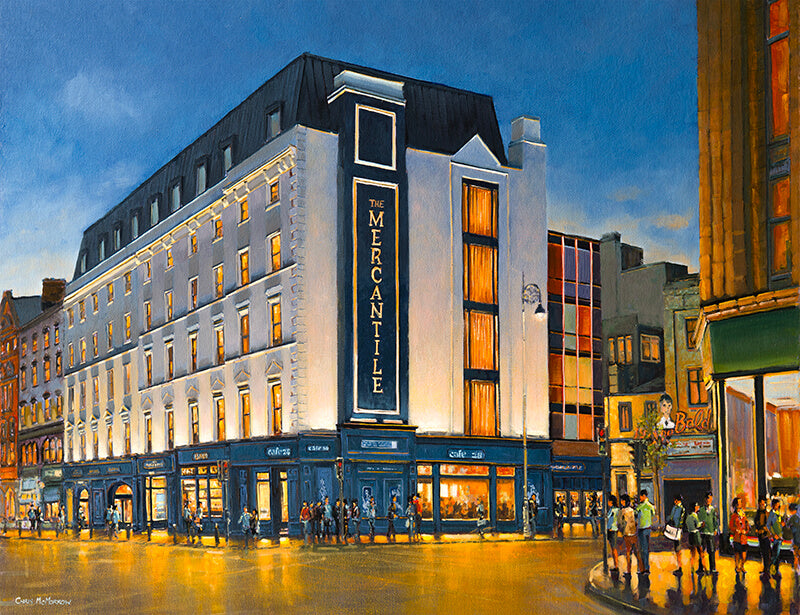 City street scene with 'The Mercantile' building at night.